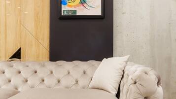 A beige tufted sofa with a cushion, positioned on a light-colored rug.
