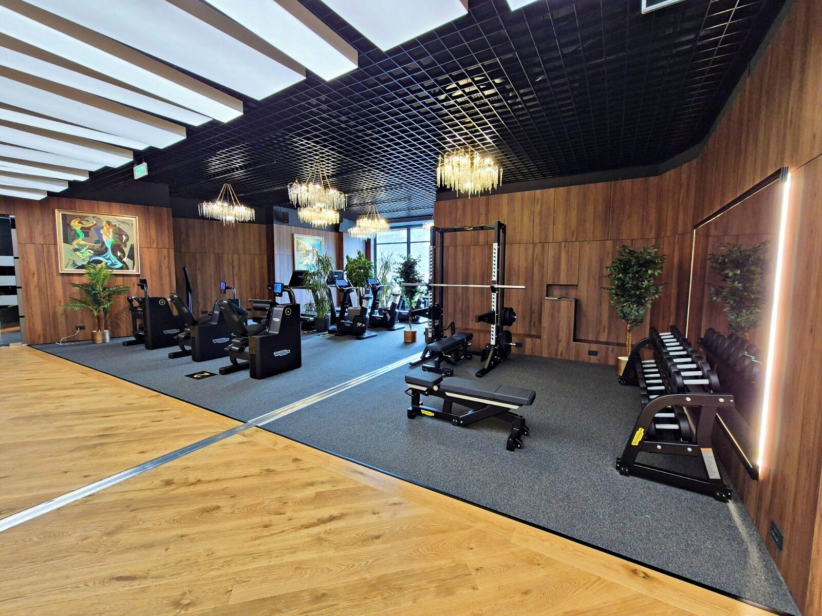 A gym with exercise equipment, wooden walls, and large windows.