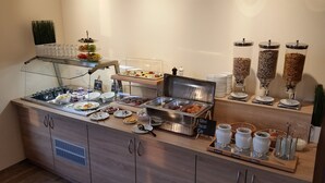 A buffet setup with various food items and condiments. - Hotel Vita Berlin (Berlin)