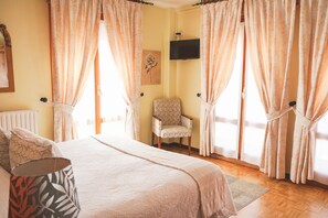 Une chambre à coucher avec un lit, une chaise et des rideaux.