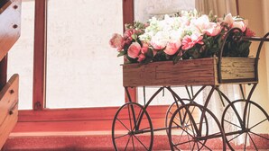 A wooden staircase with a cart of flowers and potted plants. - Hostal Docar (Lerma)