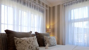 A neatly made bed with white bedding and several pillows, including patterned ones. - Strandhotel Villa Louisa & Appartementhäuser Villa Josephine und Christine (Breege)