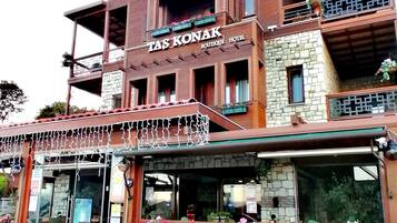 En bygning med flere etager, med et skilt der siger "TAS KONAK BOUTIQUE HOTEL".