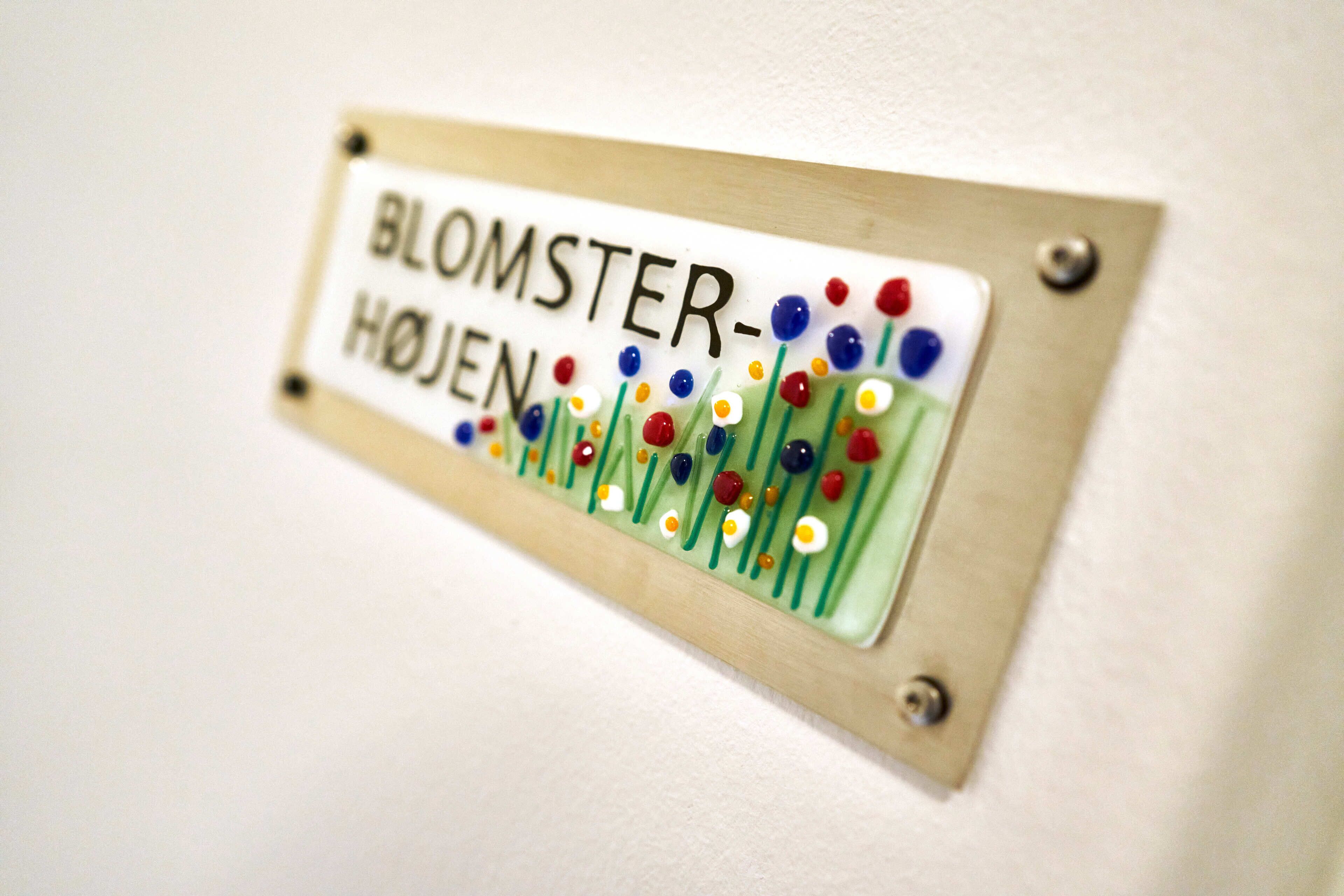 A sign with the text "BLOOMSTER-HOJE" and colorful decorations.