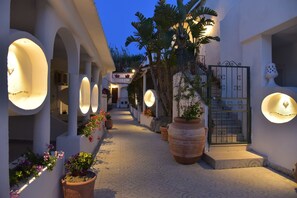 A corridor with arches, potted plants, and a gate. - Junior Village Vacanze&Relax (Forio)