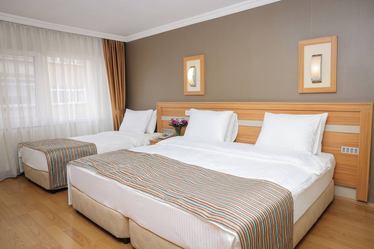 Family Triple Room | Minibar (free items), in-room safe, desk, laptop workspace