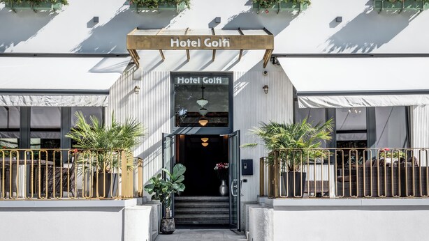 The entrance to Hotel Golfi with a clear sign, steps leading up to the entrance, and potted plants on either side. - Hotel Golfi (Podebrady)