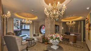 A lobby with chandeliers, a reception desk, a sofa, and a coffee table. - Viore Hotel (Istanbul)