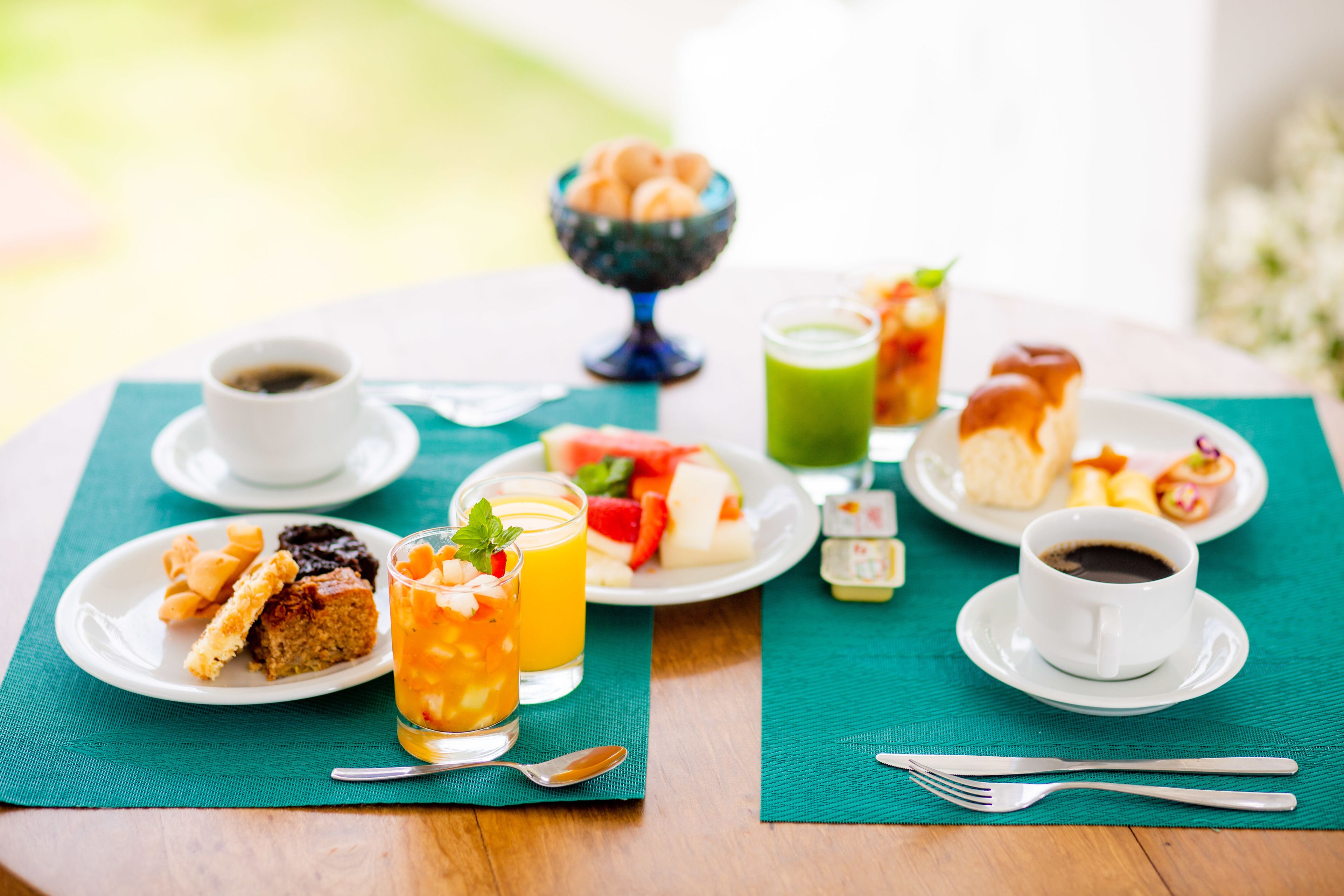 A breakfast setting with various food items and drinks on a table.
