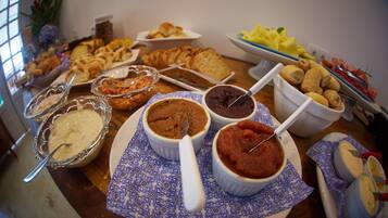 Una mesa de buffet con diferentes opciones de comida, incluyendo pasteles, salsas y pan.