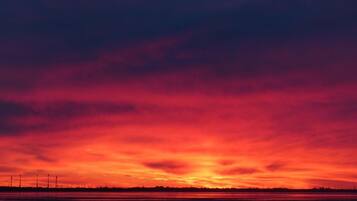 Un atardecer sobre un cuerpo de agua con un horizonte lejano.