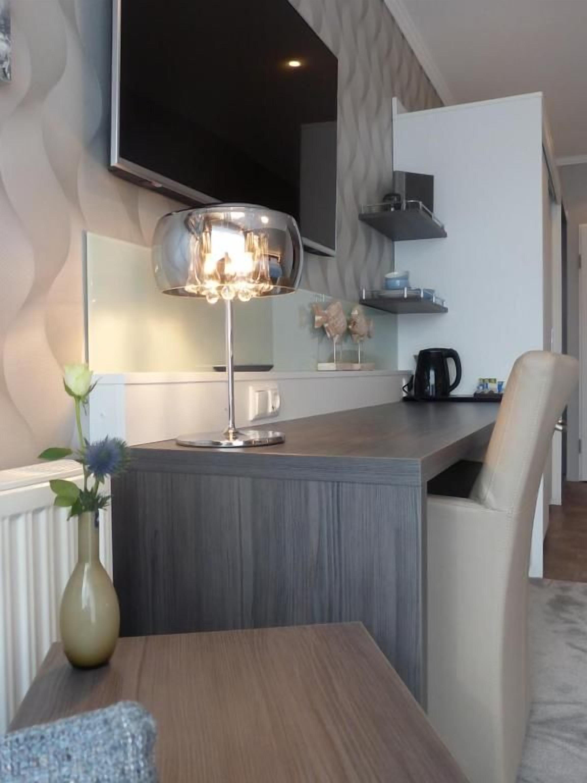 A modern kitchen with a central island, a dining table, and a chair.