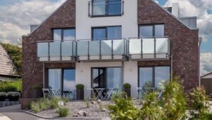 A modern two-story house with a balcony, brick exterior, and large windows. - Pension an Bord (Varel)