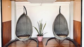 A room with two hanging chairs, a potted plant, and a 'Welcome' sign. - Anton's Inn Hotel (Balanga)