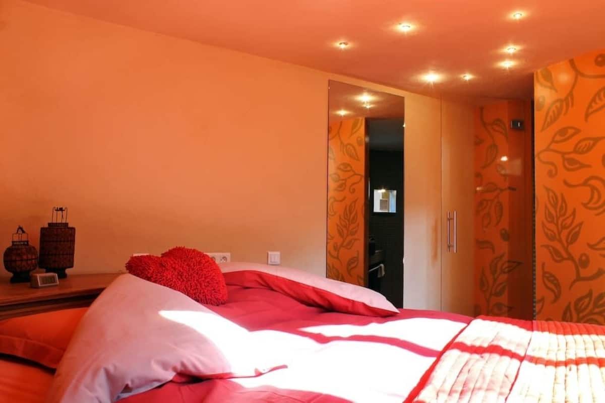 A hotel room with a bed, a nightstand, and a wardrobe.