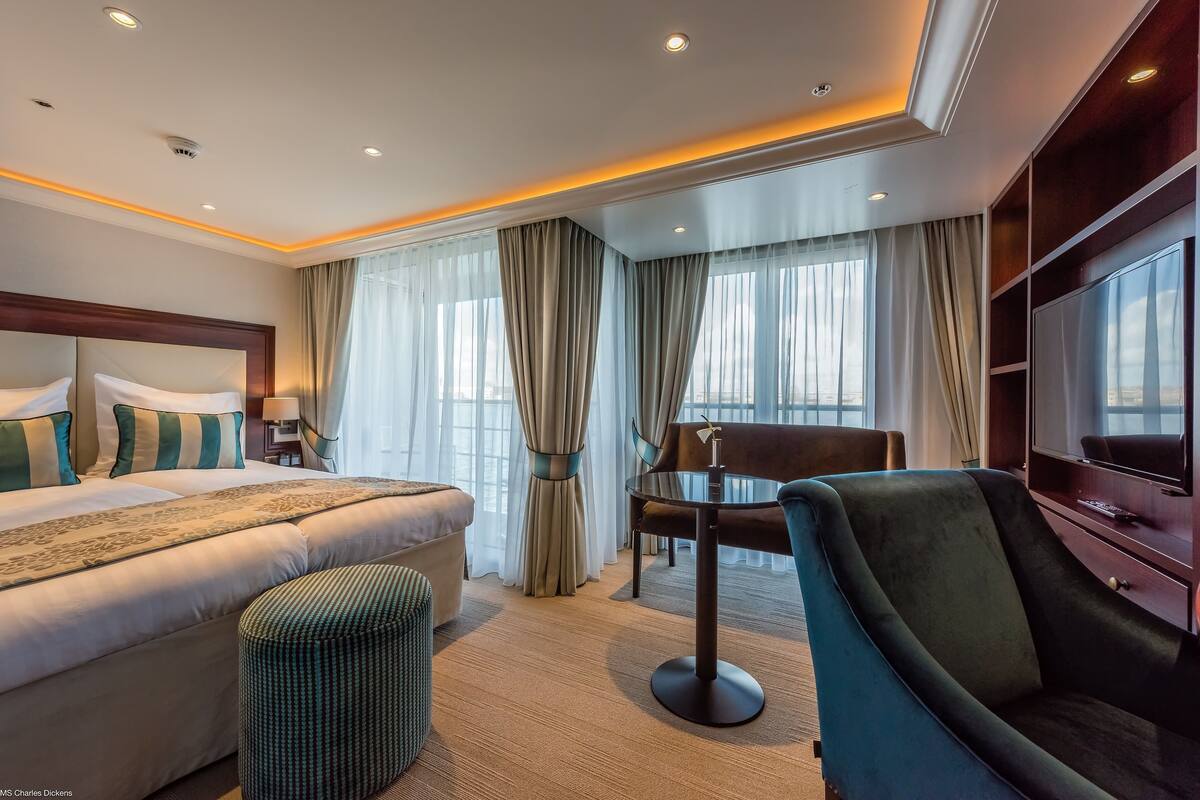 Une chambre d’hôtel dotée d’un grand lit, d’un coin salon et d’une télévision.