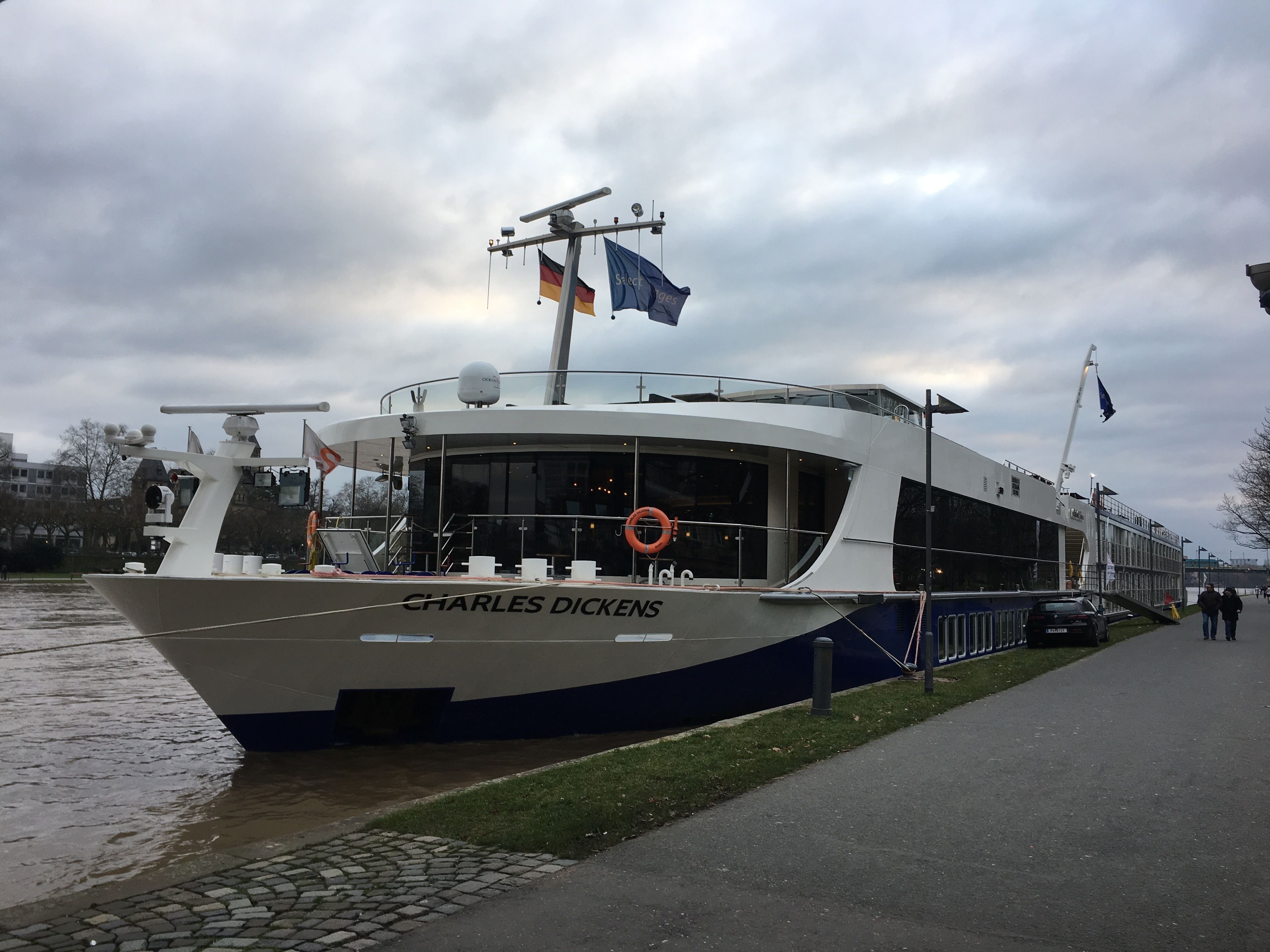 Ein Boot namens 'Charles Dickens' liegt an einem Hafen mit einem Steg daneben.