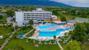 Un hôtel doté d’une grande piscine, de nombreux balcons et offrant une vue sur le paysage environnant.