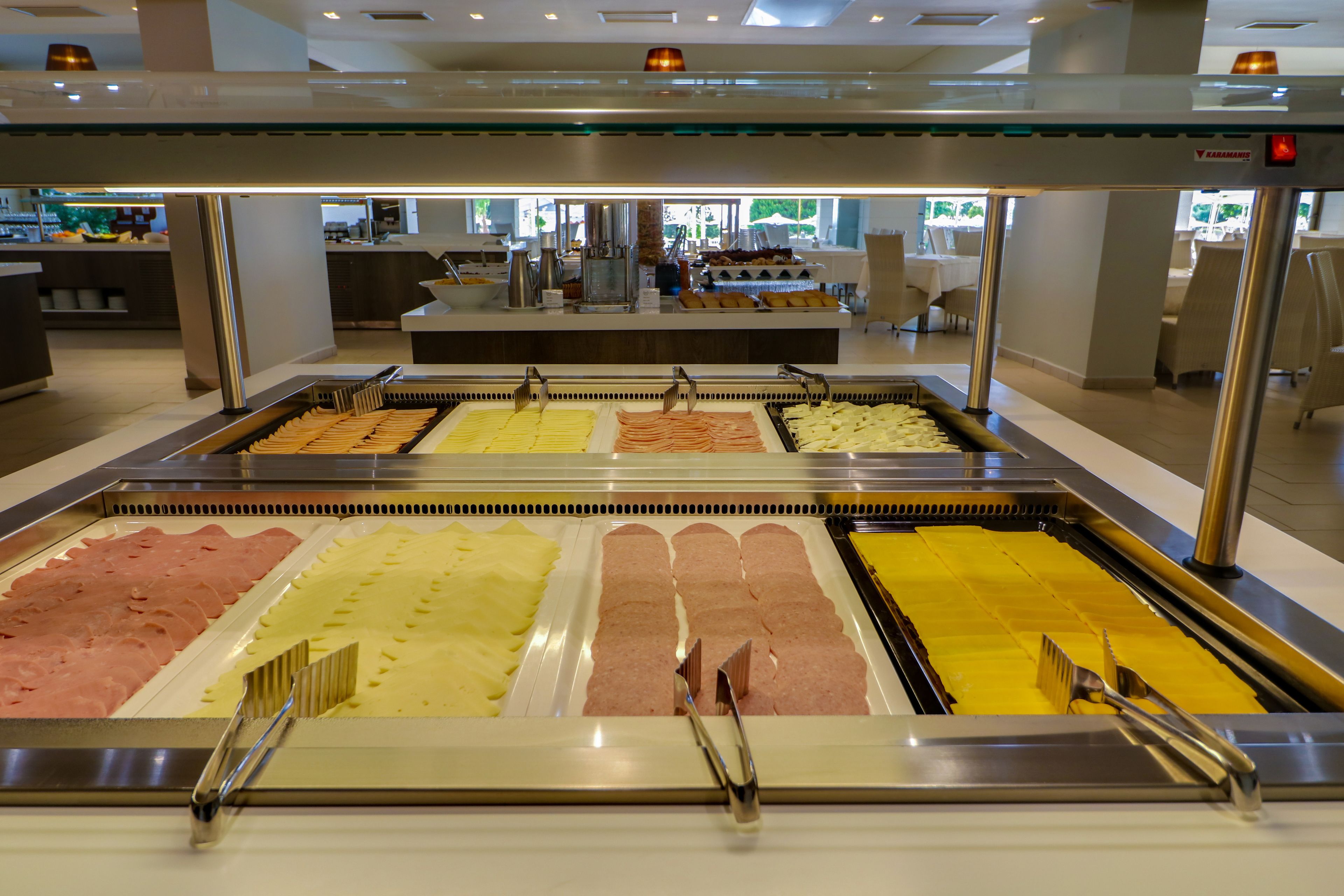 Een buffetgedeelte met diverse themastations, waaronder vleeswaren en kazen.