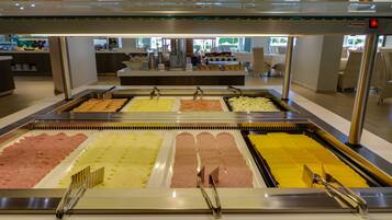 Een buffetgedeelte met diverse themastations, waaronder vleeswaren en kazen.