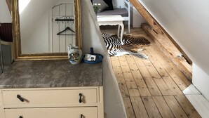 A room with a dresser, a mirror, a bench, and a zebra rug. - Køge Bed & Kitchen (Koge)
