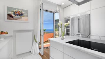 Apartamento, 3 quartos | Cozinha privada | Geladeira grande, micro-ondas, fogão, cooktop