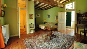 A room with a bed, a round table, a chair, and a bookshelf. - Château du Plessis - Anjou (La Jaille-Yvon)