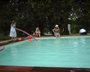 Una piscina al aire libre de temporada, sombrillas