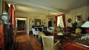 A traditional room with a fireplace, seating area, and a chandelier. - Château du Plessis - Anjou (La Jaille-Yvon)