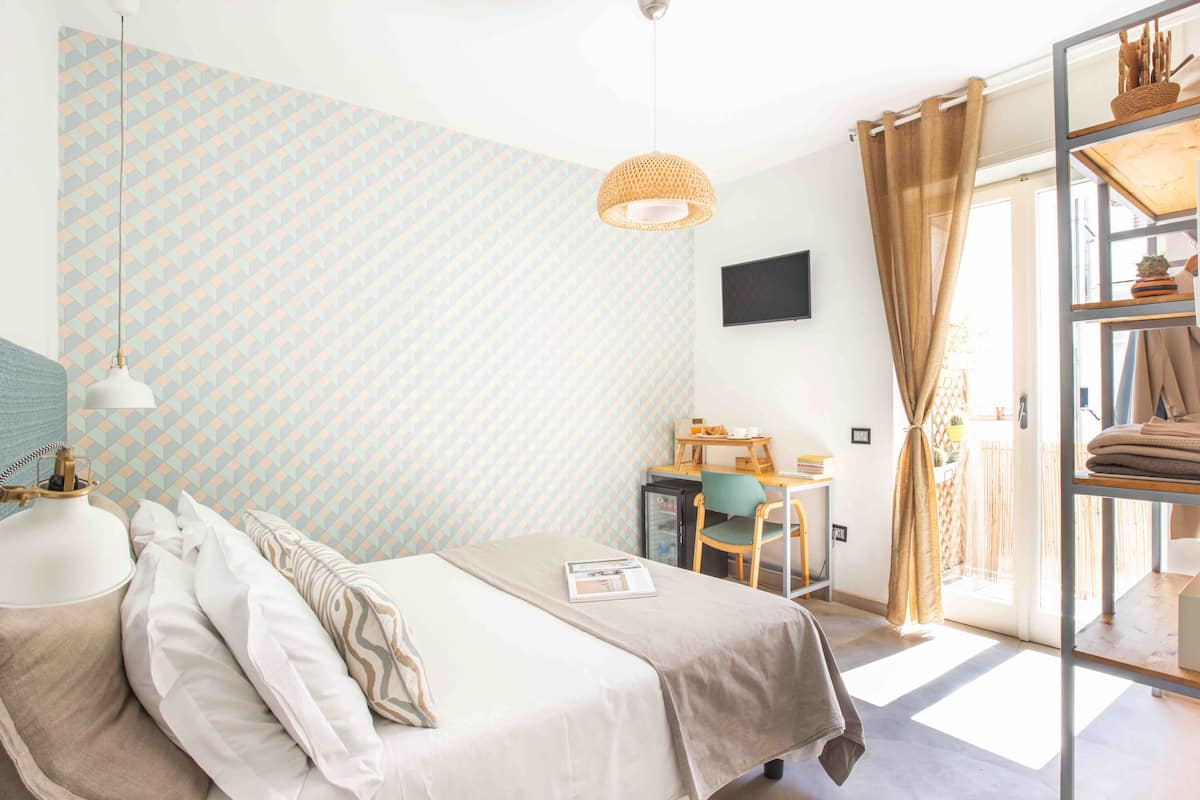 A bedroom with a bed, a desk, and a chair.