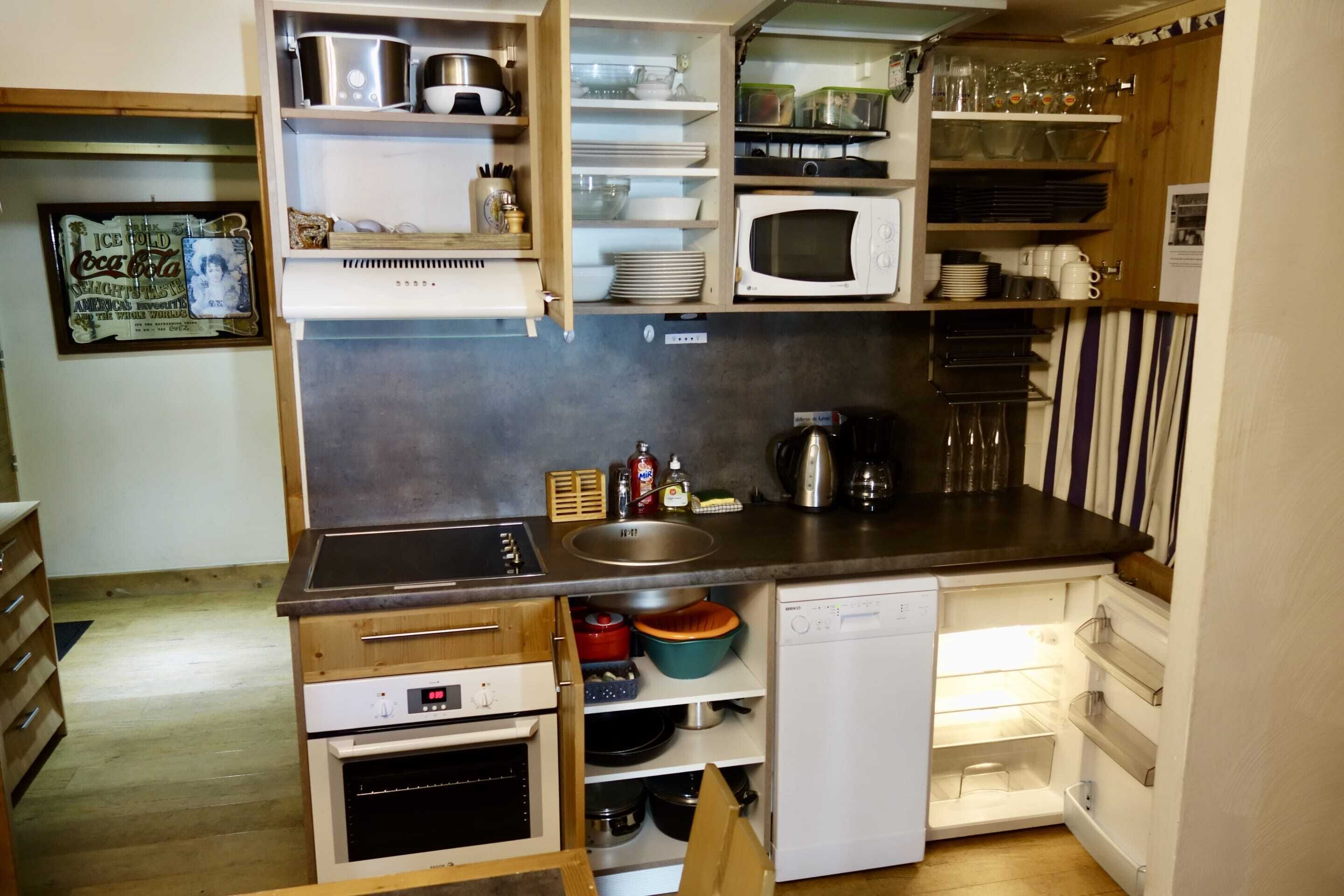 A compact kitchen with a microwave, sink, and built-in oven.
