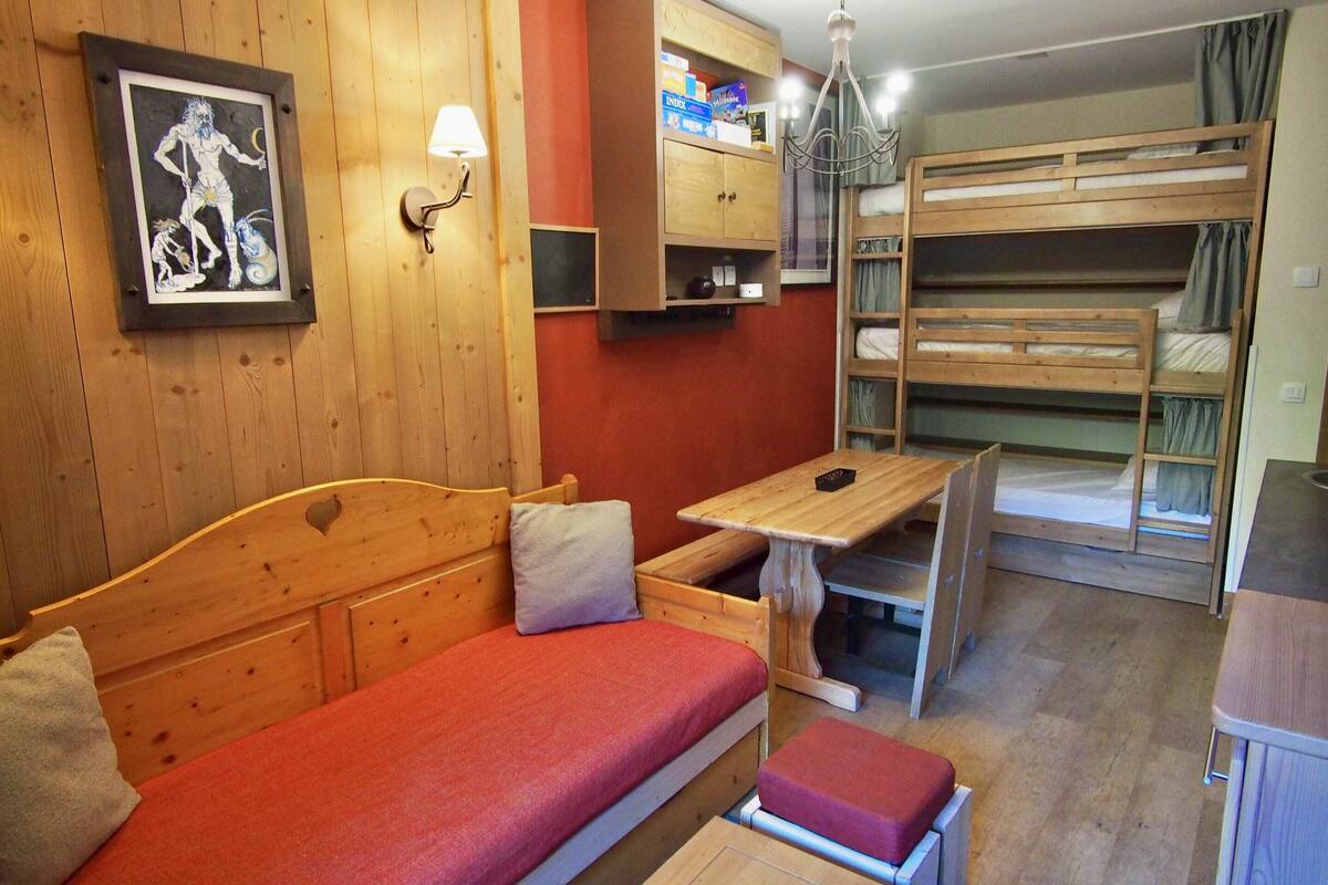 A cozy room with a wooden bed, a small desk, and bunk beds.