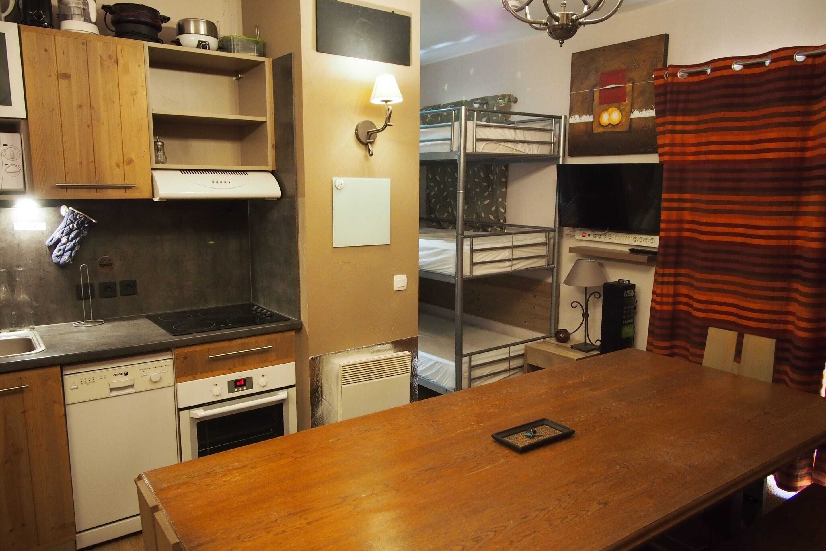 Una cocina compacta con armarios de madera, horno integrado y lavavajillas.