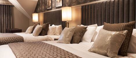 A hotel room with a large bed, two bedside tables, and a headboard with wall art.
