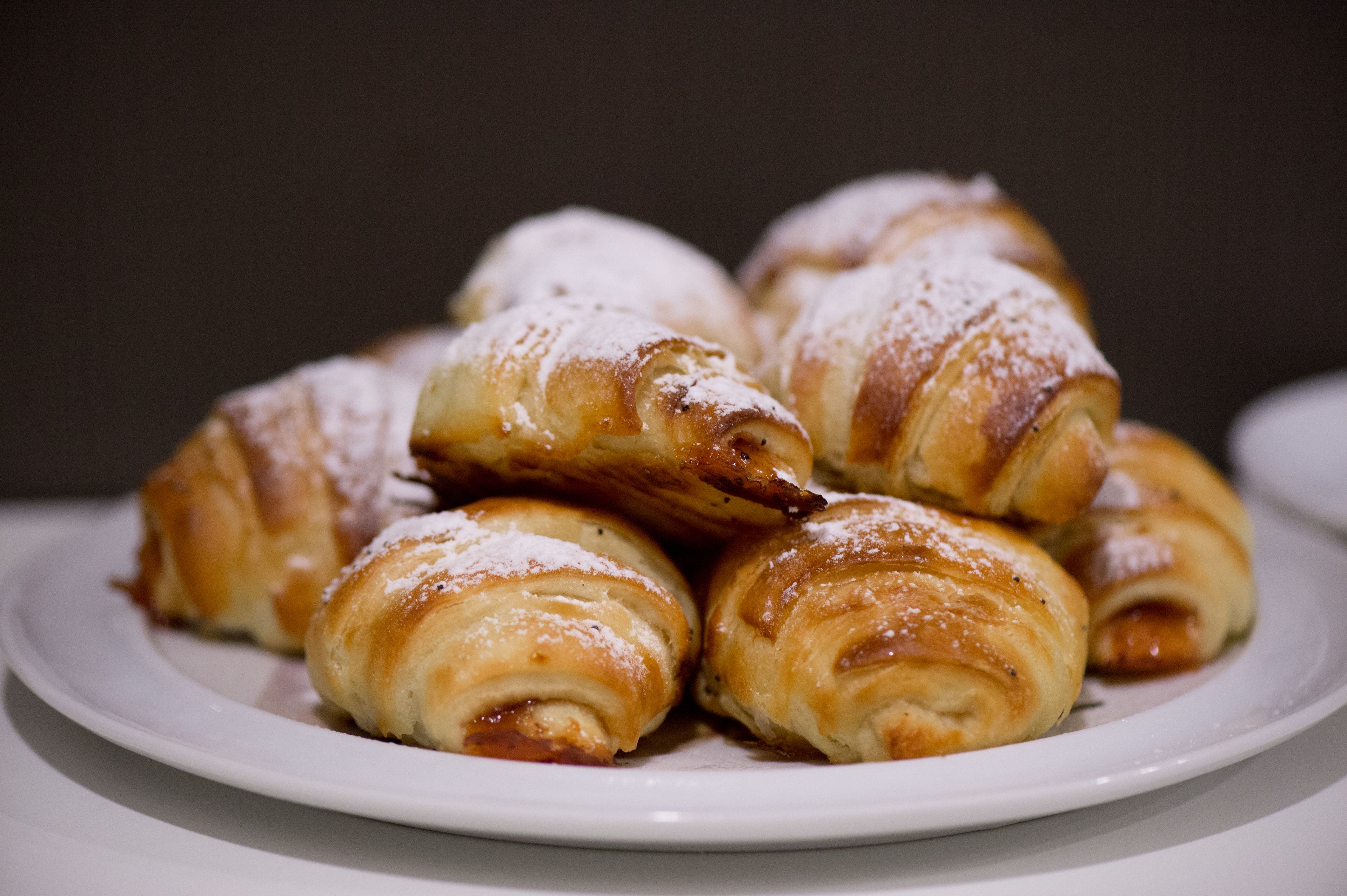 A plate of pastries with powdered sugar.