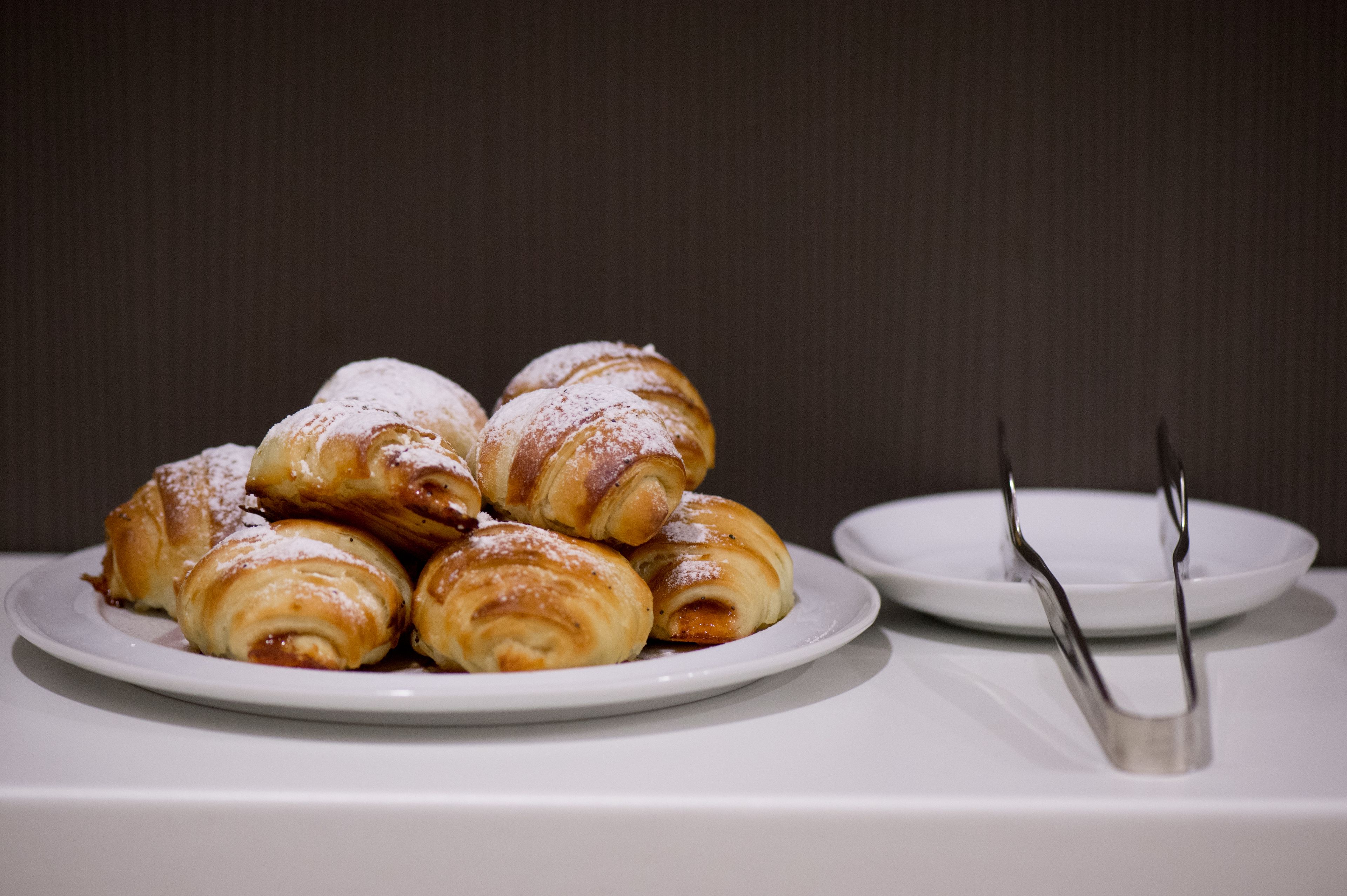 A plate of pastries with a plate of utensils beside it.