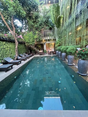 A pool with lounge chairs and potted plants. - Won Residence & Spa (Siem Reap)