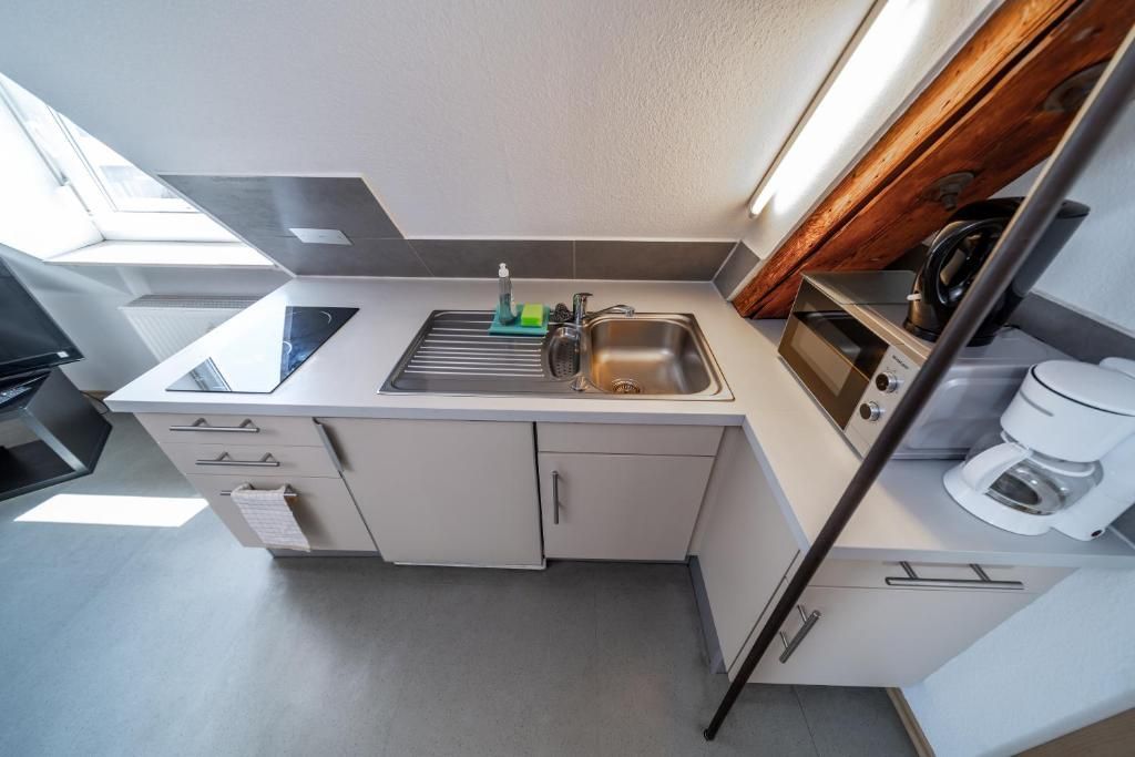 A compact kitchenette with a sink, a coffee maker, and a small countertop.
