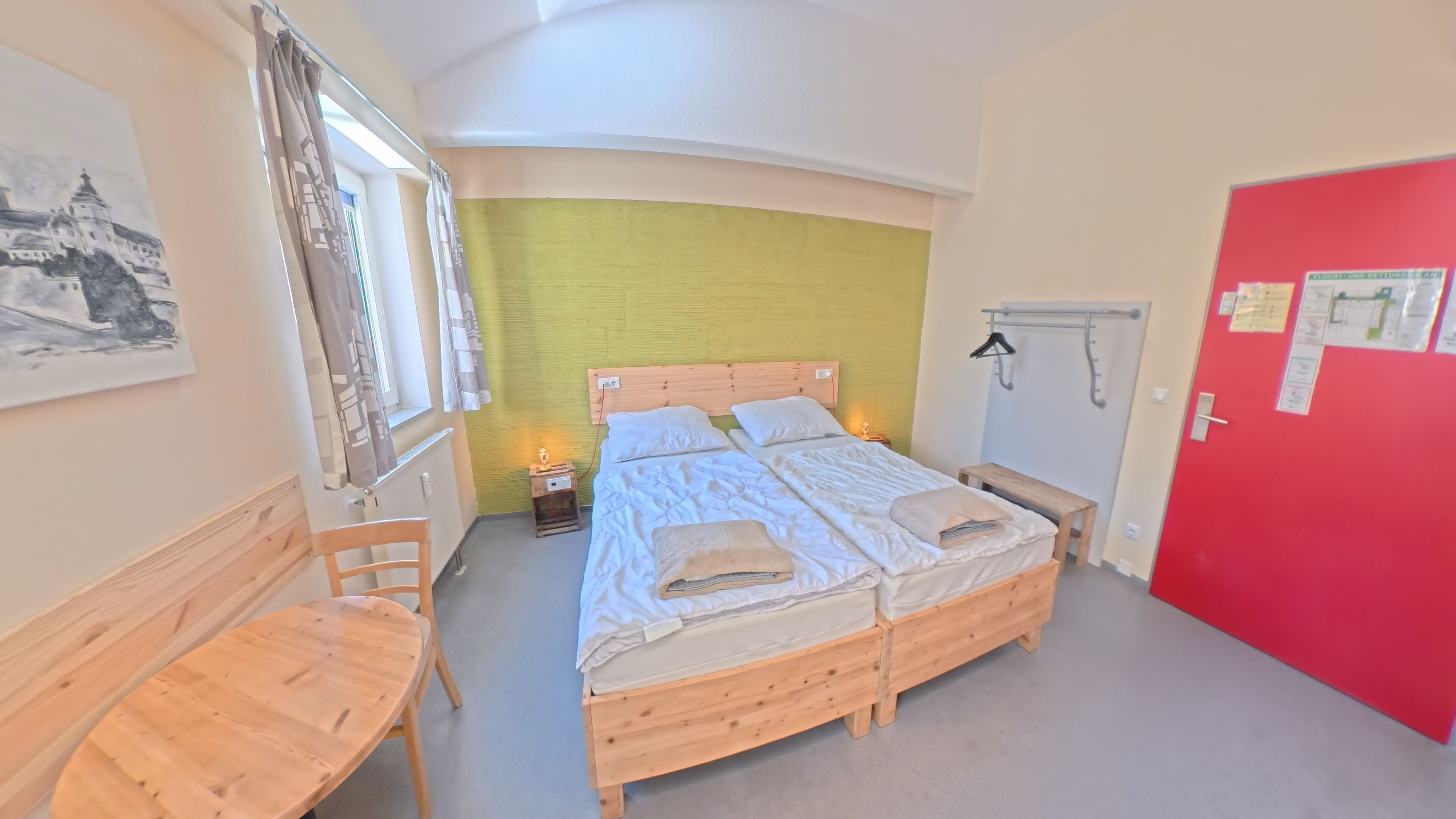 Ein Zimmer mit einem Bett, einem Schreibtisch und einem Stuhl.