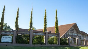 A building with a sign for Shawu Lodge, featuring a contact number and a website URL. - Shawu Lodge & Conference (Bloemfontein)