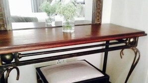 A wooden desk with a cushioned bench, a mirror, and a window with curtains. - Shawu Lodge & Conference (Bloemfontein)