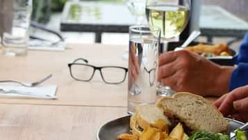 Una mesa de comedor con comida, vasos y un menú.