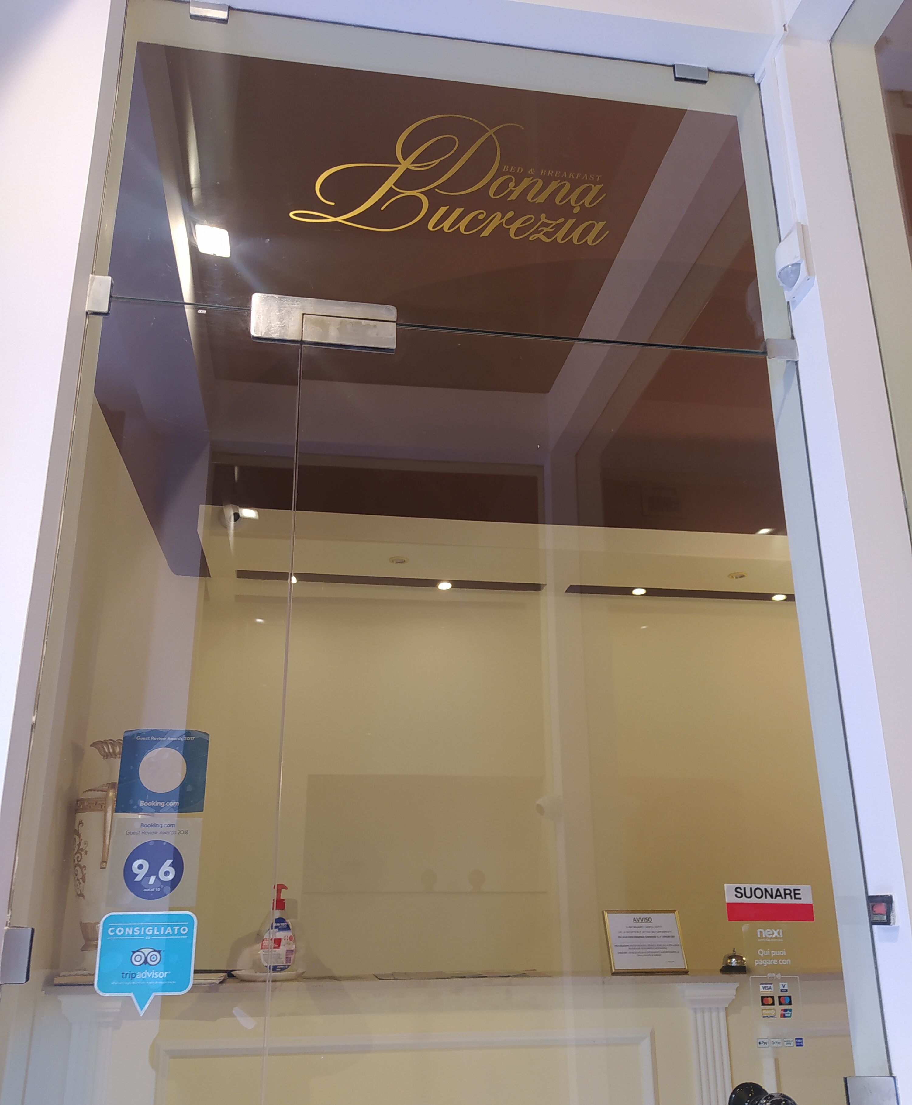 Een hotelinterieur met een bord waarop 'Donna Lucrezia' staat en een bord met 'Consigliato', wat een Tripadvisor service aangeeft.