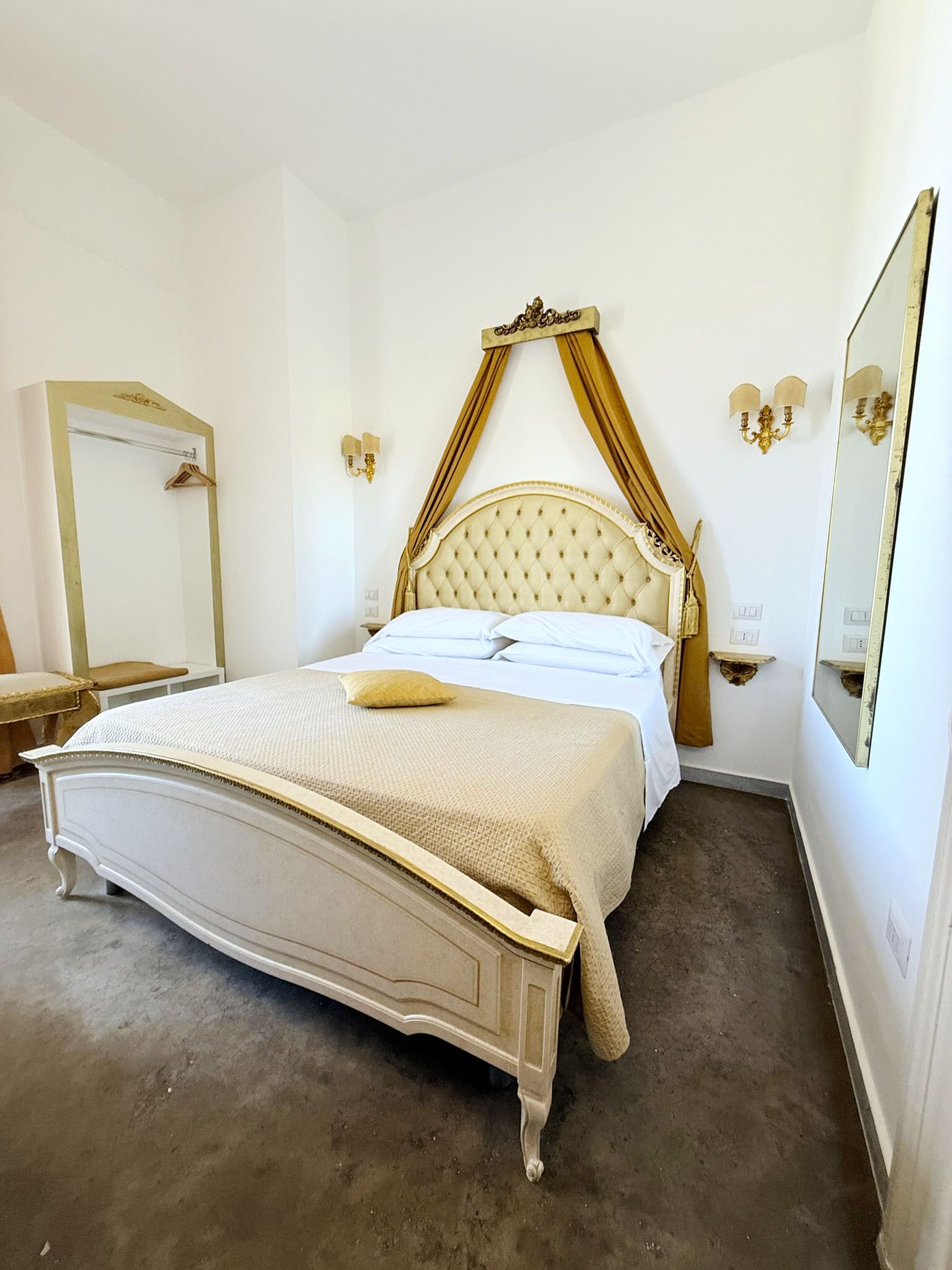 Une chambre à coucher avec un grand lit, une coiffeuse avec un miroir et une petite table.