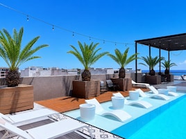 Una piscina al aire libre, tumbonas