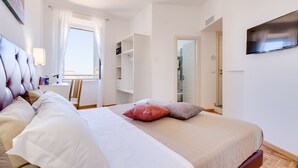 A bedroom with a bed, a TV, a desk, and a wardrobe. - Dolce Luxury Rooms (Rome)
