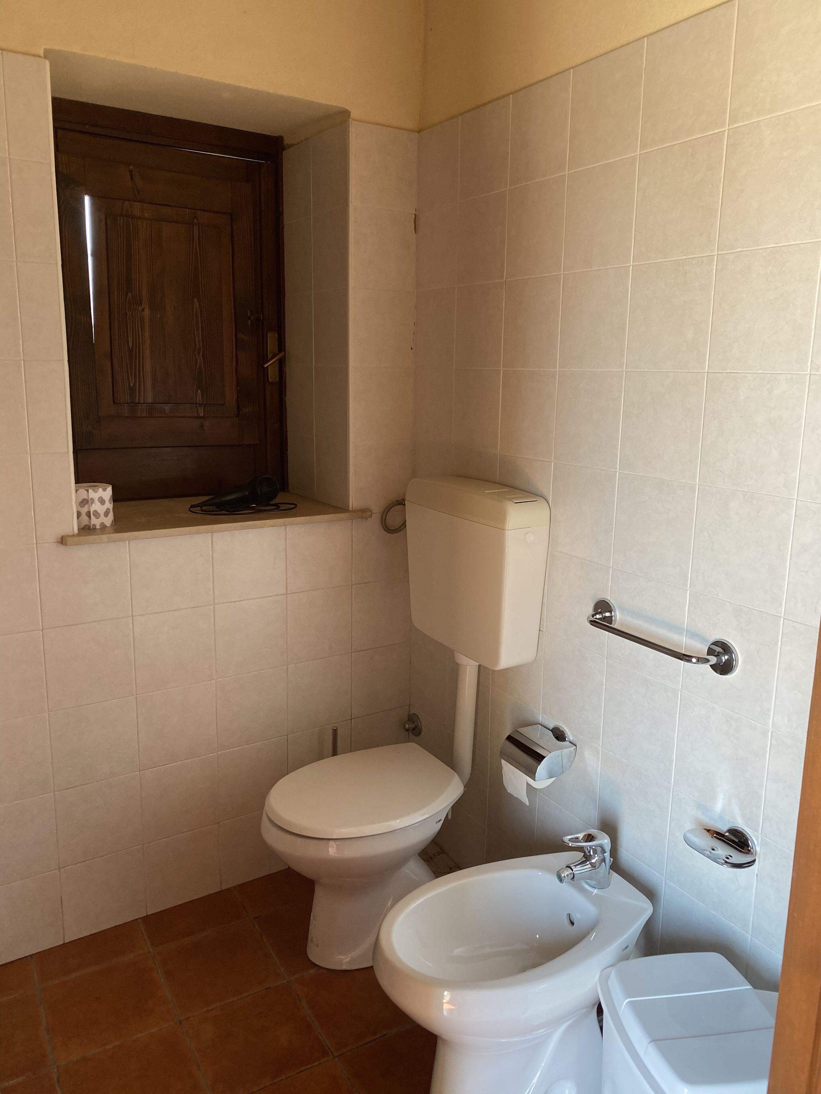 A small bathroom with a toilet, bidet, and sink.