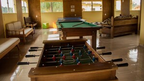 Une pièce équipée d’un baby-foot, d’une table de billard et d’un canapé.