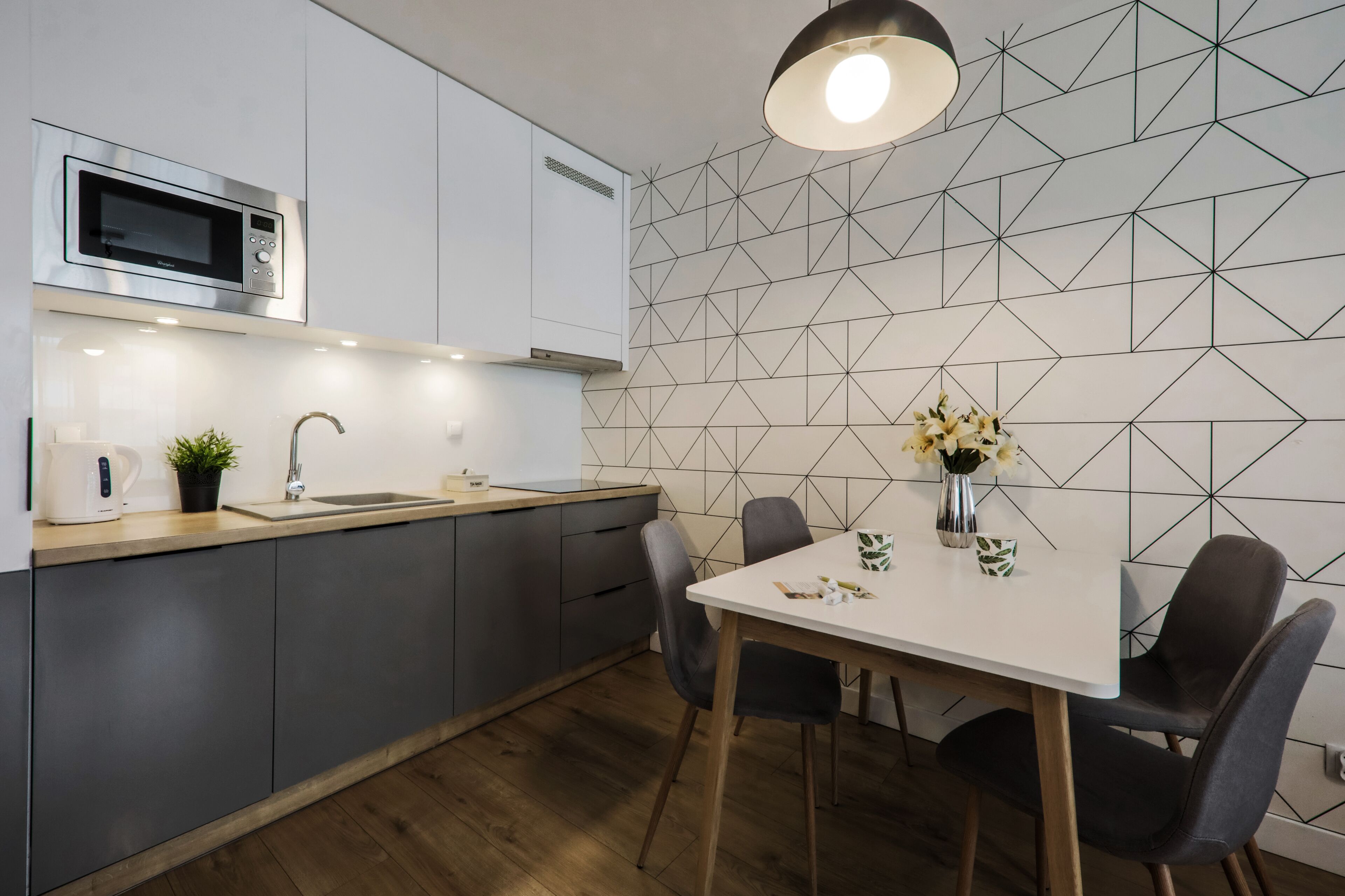 A modern kitchen with a microwave, sink, and dining area.
