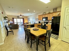 Una cocina amplia con armarios de madera, una mesa de comedor y sillas.
